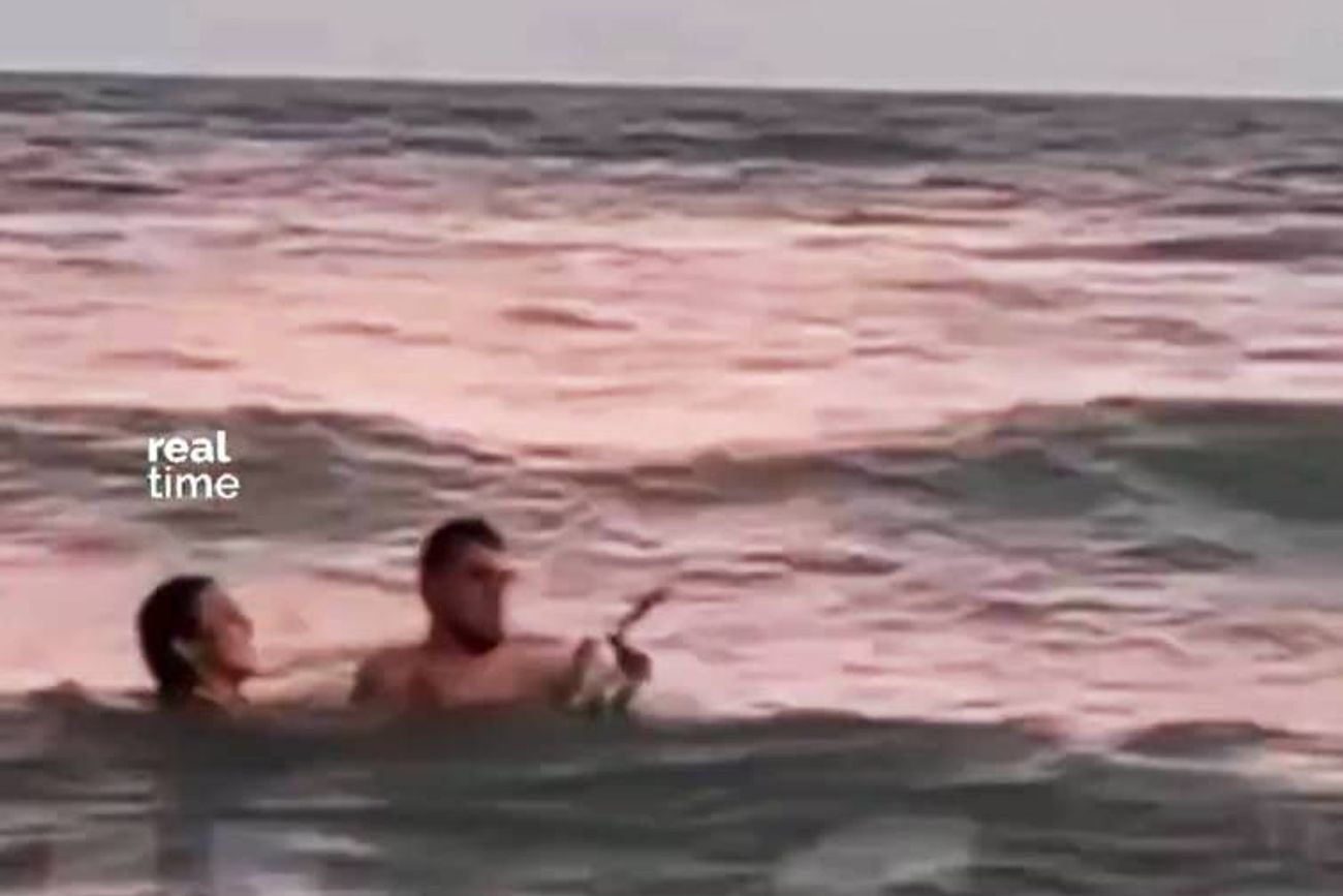 Pareja sacó un pingûino del mar para sacarse una foto en Monte Hermoso. 