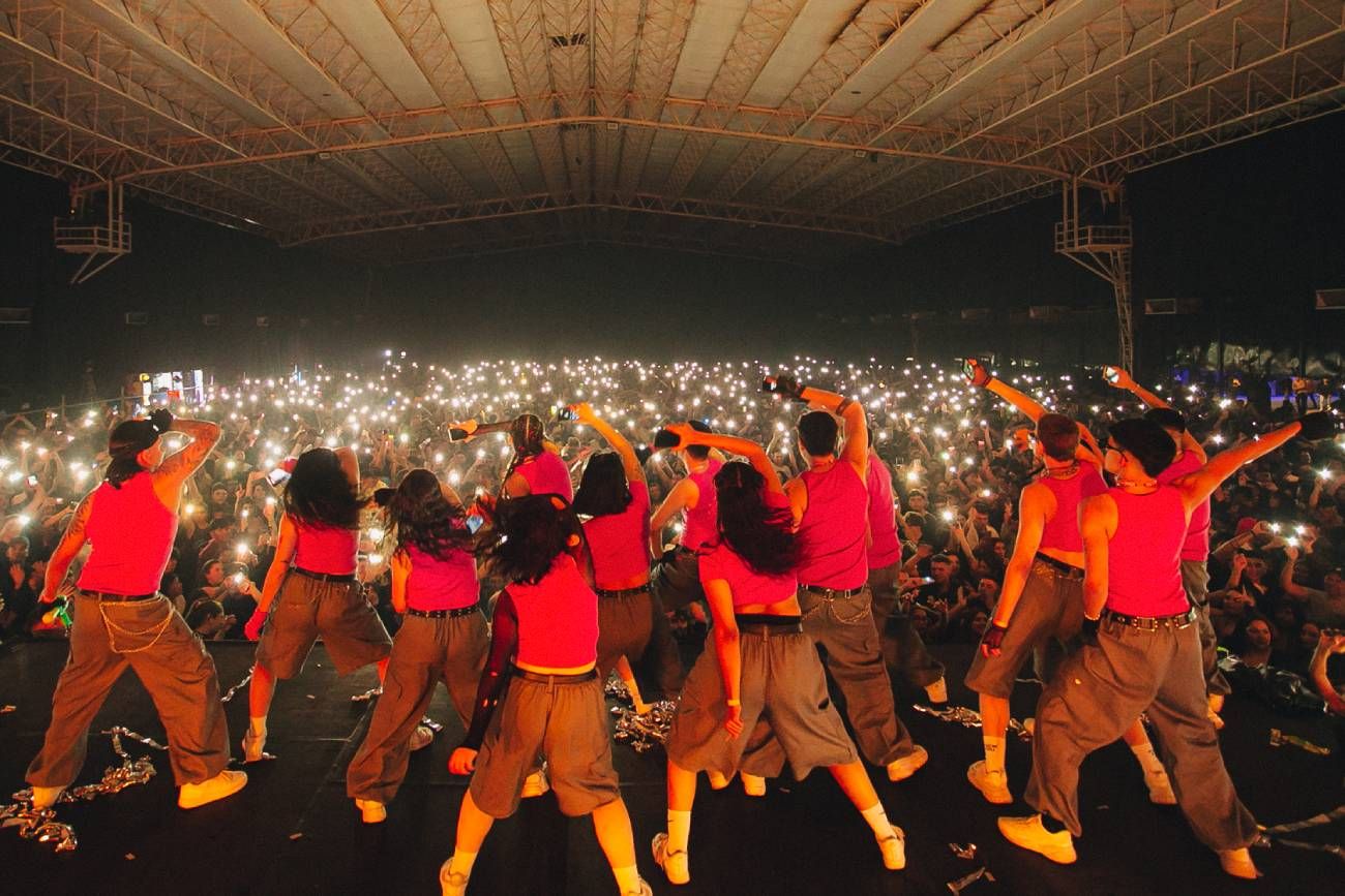 El cuerpo de baile de la Club Reggaetón, tira pasos ante una multitud. 