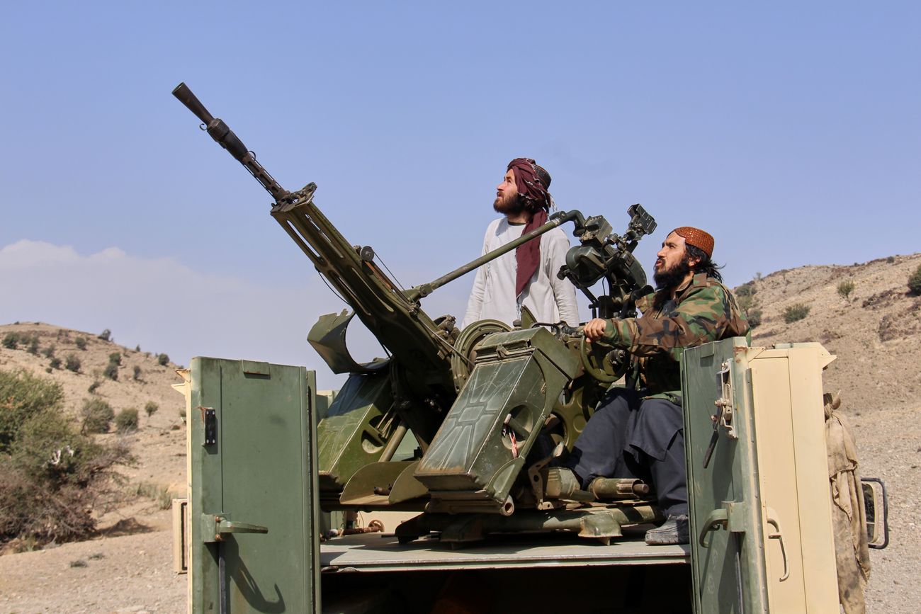 Combatientes talibanes miran hacia arriba mientras custodian una camioneta armada en el lado afgano del cruce de Ghulam Khan con Pakistán.