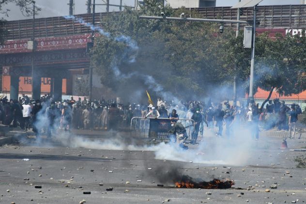Musulmanes chiítas responden a gritos a un proyectil de gas lacrimógeno disparado por la policía para dispersarlos durante una protesta en condena por el asesinato del líder supremo iraní, el ayatolá Alí Jamenei, en Karachi, Pakistán, el domingo 1 de marzo de 2026. (Foto AP/Ali Raza)