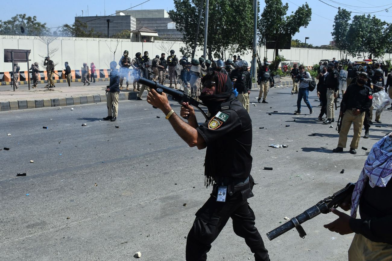 Un agente de policía dispara gas lacrimógeno para dispersar a musulmanes chiítas durante una protesta en condena por el asesinato del líder supremo iraní, el ayatolá Ali Khamenei, cerca del consulado estadounidense en Karachi, Pakistán, el domingo 1 de marzo de 2026. (Foto AP/Ali Raza)