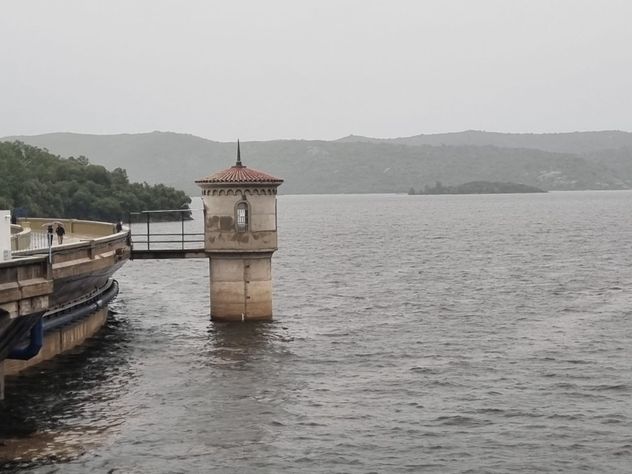 Dique La Viña. El embalse está lleno y eroga excedentes por sus compuertas. 