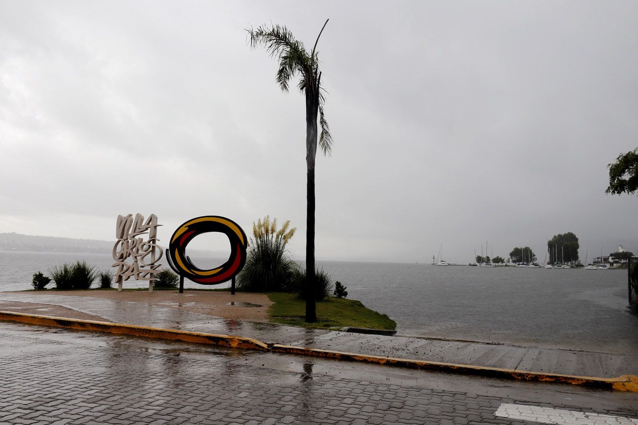 Lago San Roque, en la costanera de Villa Carlos Paz, este jueves. El embalse quedó repleto y eroga aguas por vertedero y por válvulas. 