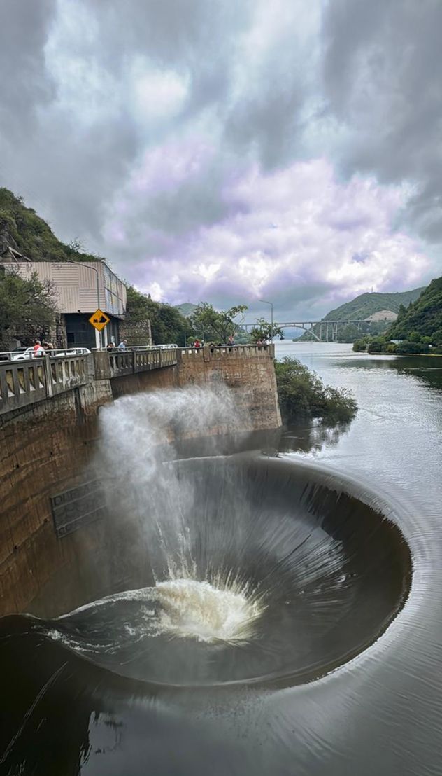 El dique San Roque con agua sobre el nivel de su embudo. También tiene sus válvulas de evacuación abiertas. 