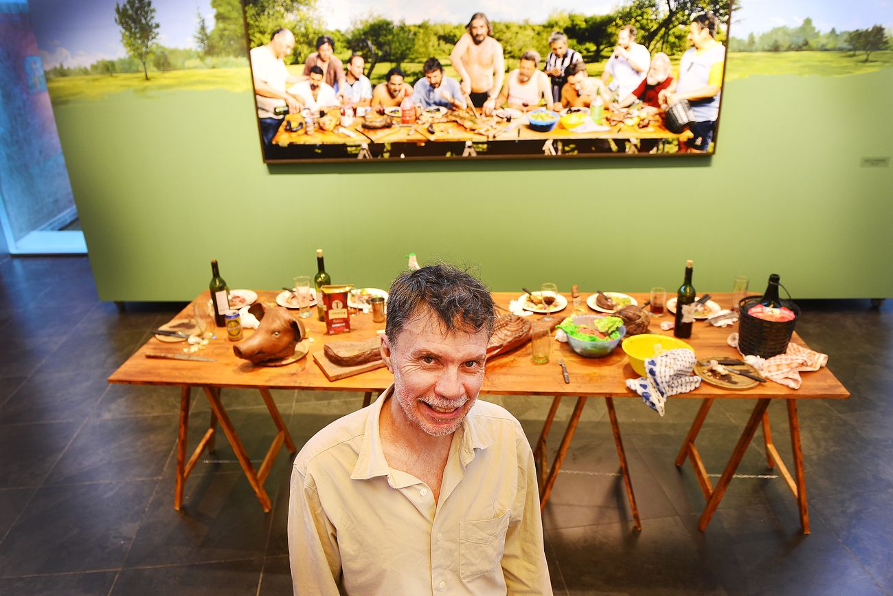 El fotógrafo  y artista visual Marcos López con su icónica obra  "Asado en Mendiolaza". Foto Javier Ferreyra