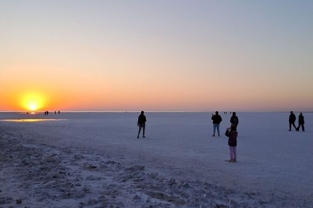 Uno de los momentos más especiales del día llega al atardecer, cuando el sol comienza a caer sobre el horizonte blanco del salar.