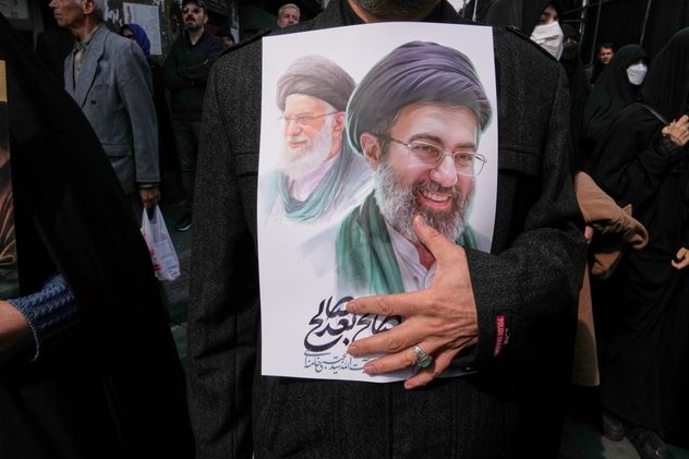Un doliente sostiene un cartel que muestra al Ayatolá Mojtaba Khamenei, a la derecha, el sucesor de su difunto padre Ayatolá Ali Khamenei, a la izquierda, como líder supremo, durante la procesión fúnebre de altos funcionarios militares iraníes y civiles asesinados durante la campaña de EE. UU.-Israel en Teherán, Irán, el 11 de marzo de 2026. (Foto AP/Vahid Salemi, Archivo)
