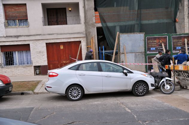 Auto mal estacionado frente a garajes.