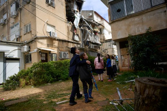 Jóvenes examinan los daños en un edificio de apartamentos un día después de que fuera alcanzado por un misil iraní en Bnei Brak, Israel, el miércoles 25 de marzo de 2026. (Foto AP/Ohad Zwigenberg)