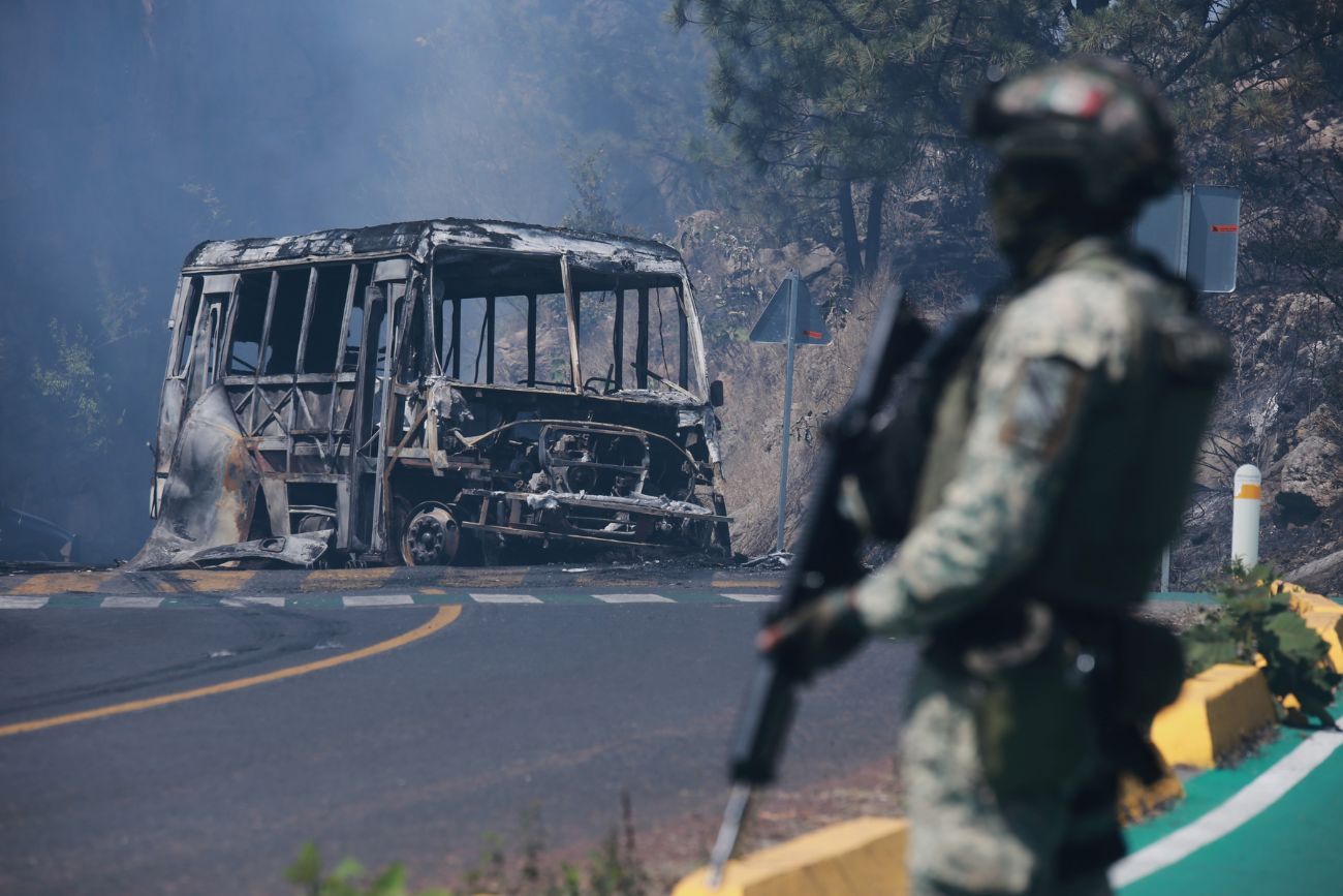 Un soldado monta guardia junto a un vehículo calcinado tras ser incendiado en Cointzio, estado de Michoacán, México, el 22 de febrero de 2026, tras la muerte del líder del Cártel Jalisco Nueva Generación, Nemesio Oseguera, conocido como "El Mencho". (Imagen ilustrativa)