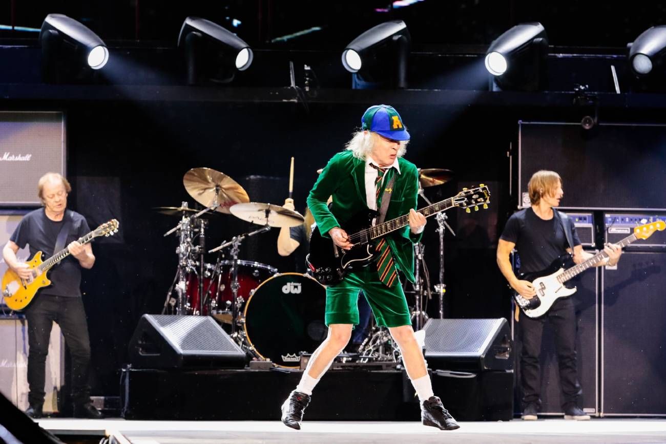 Angus Young, durante uno de los dos shows que ya ofreció en River. Atras, lo acompañan su sobrino Stevie y el bajista Chris Chaney. (X @acdc/  
@ChristieGoodwin)