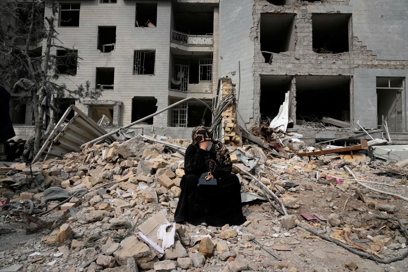 Una mujer se sienta sobre escombros frente a un edificio residencial dañado el pasado domingo durante la campaña aérea de Estados Unidos e Israel en Teherán, Irán, 12 de marzo de 2026. (Foto Vahid Salemi)