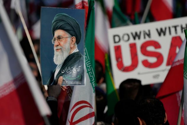 Un cartel del difunto Líder Supremo iraní Ayatolá Ali Jamenei y un letrero antiestadounidense son llevados en Teherán, Irán, el miércoles 1 de abril de 2026, durante un desfile fúnebre por Alireza Tangsiri, jefe de la Armada de la Guardia Revolucionaria Islámica de Irán, y otros fallecidos en ataques israelíes a fines de marzo. (Vahid Salemi)