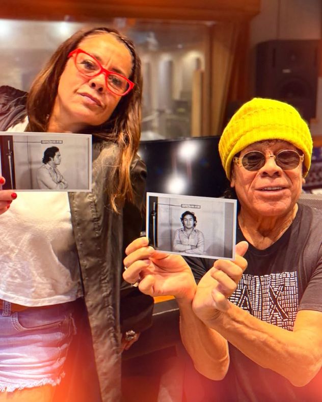 La Mona Jiménez junto a su hija Lorena sosteniendo las fotografías.