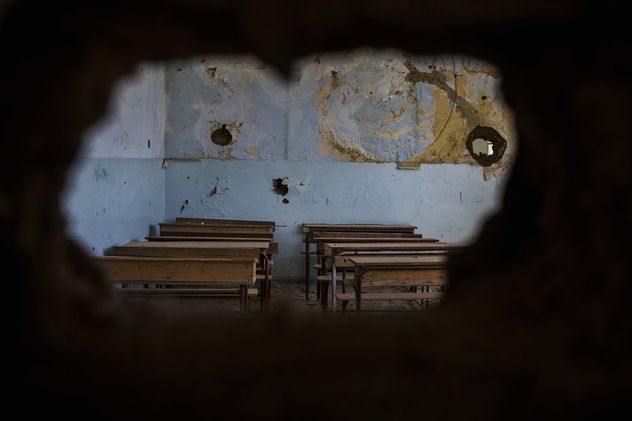 13- Al-Hasakah, Siria: un aula en ruinas se observa a través de un boquete en la pared de la escuela Tell Ruman, cerrada desde el ataque del ISIS en julio de 2015. 