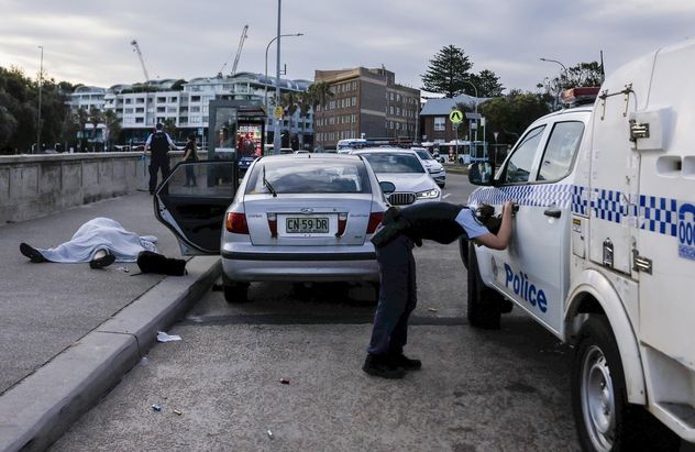 20- Un policía, visiblemente afectado, se inclina cerca de los cuerpos de Boris y Sofia Gurman. Los Gurman, que estaban a tan solo semanas de su 35.º aniversario de bodas. Murieron durante el ataque terrorista en Bondi Beach, Sídney, Australia, mientras intentaban desarmar a uno de los atacantes. 