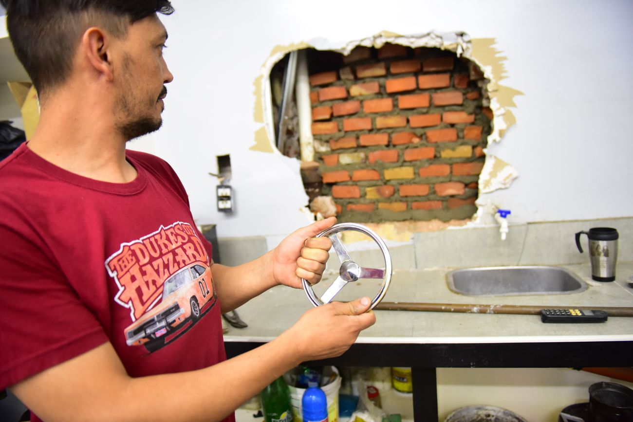 La víctima muestra lo que quedó de la caja fuerte que la banda se robó el fin de semana en pleno centro. (Javier Ferreyra)