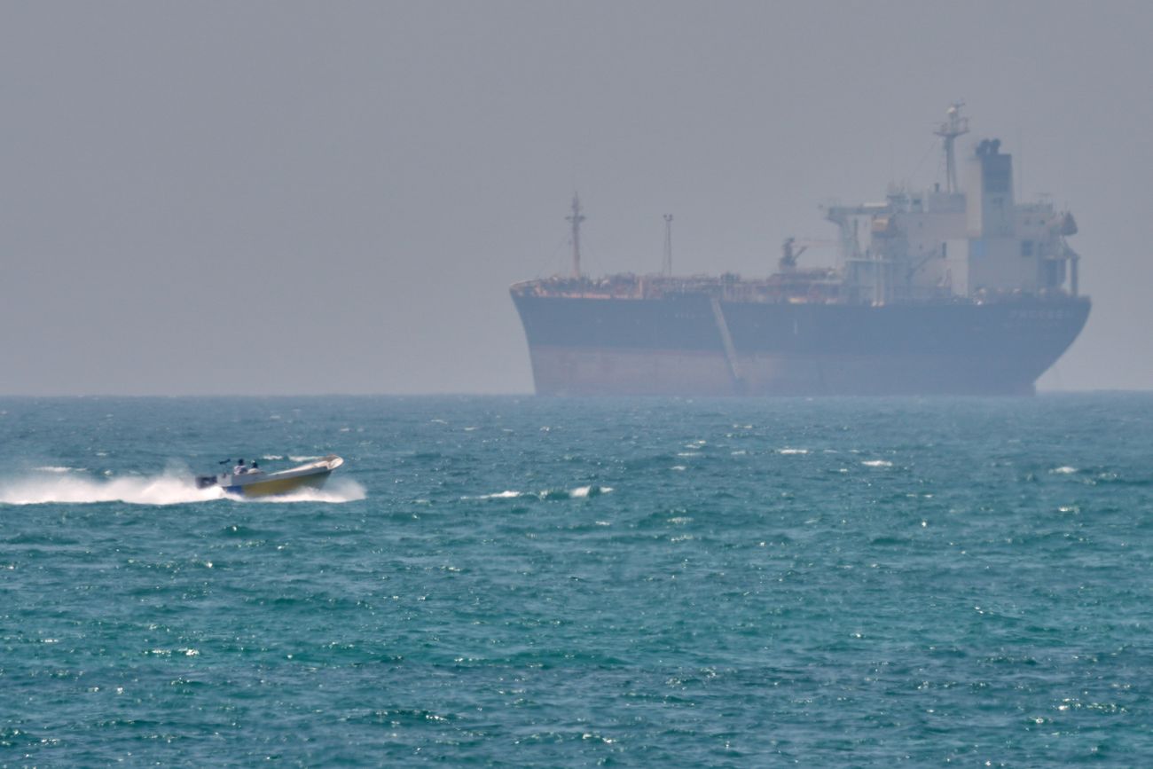 Una lancha navega junto a un petrolero anclado en el Estrecho de Ormuz frente a la isla Qeshm, Irán, sábado 18 de abril de 2026. (Asghar Besharati / AP)