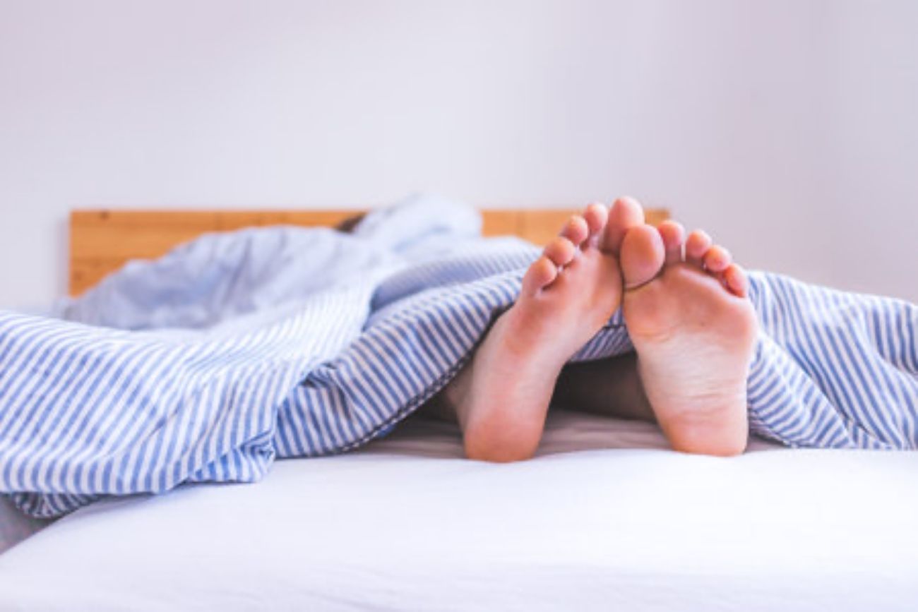 Por qué algunas personas duermen con los pies afuera y qué dice la ciencia