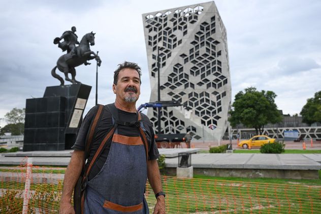 El escultor encargado de la restauración frente al monumento.
