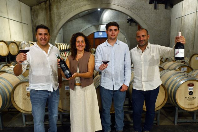El enólogo Lucas Quiroga levanta la copa junto a Ana Viola, su hijo y su hermano Julio, símbolos de la nueva generación de la bodega. 