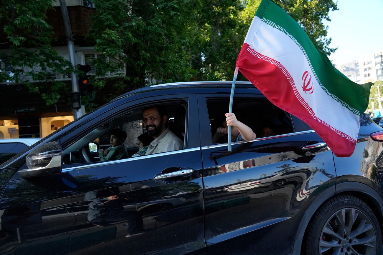 Un niño sostiene una bandera iraní a través de la ventana de un vehículo en el norte de Teherán, Irán, el viernes 1 de mayo de 2026. (Vahid Salemi)