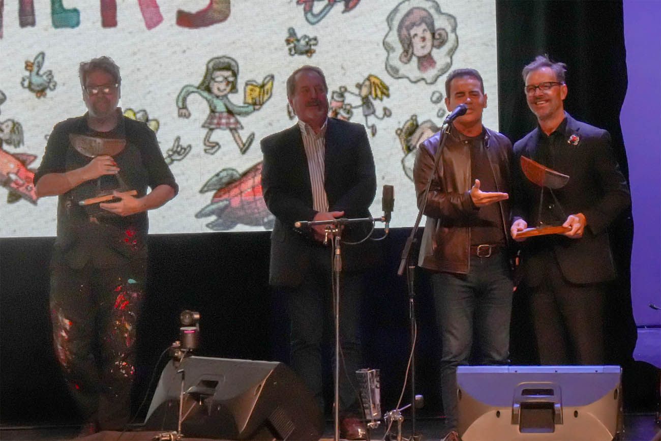 Marcelo Rodio, titular de la Agencia Córdoba Cultura, entrega la obra “La Barca”, de Inés Rozzé, a Kevin Johansen y Liniers.