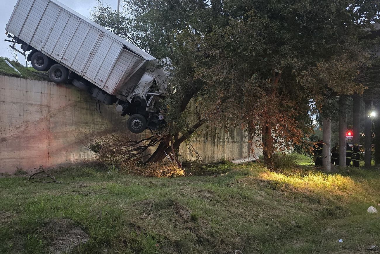 El camión colgado de la autopista tras el choque, cerca de Pilar. 