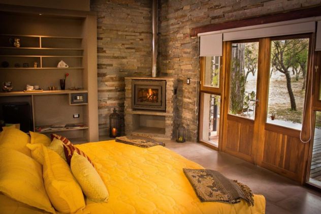 Las suites de Calma Nono están diseñadas con materiales nobles y grandes ventanales para integrar el paisaje serrano al interior del refugio.