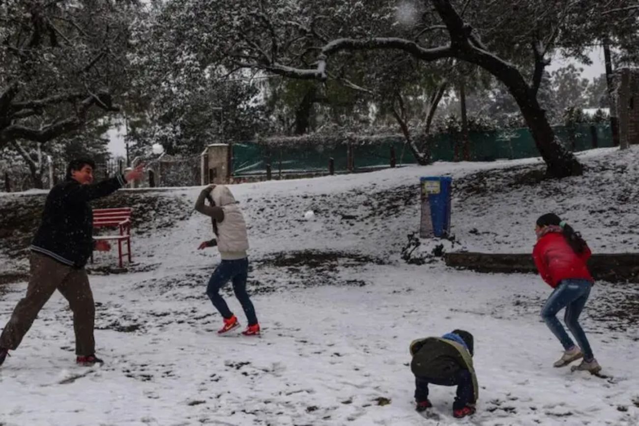 Una familia juega con la nieve en La Falda. (Archivo)
