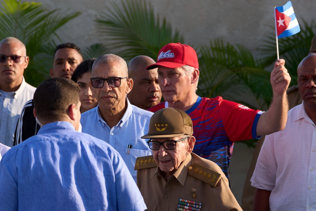 El expresidente Raúl Castro, en el centro, y el presidente cubano Miguel Díaz-Canel, detrás con una bandera, llegan a un acto conmemorativo del Día Internacional de los Trabajadores en la Plaza Antiimperialista José Martí de La Habana, Cuba, el viernes 1 de mayo de 2026. 