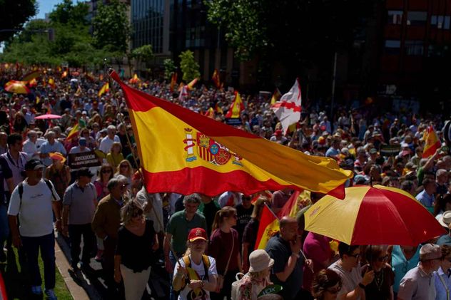 Manifestantes con banderas españolas participan en una protesta contra el gobierno del presidente Pedro Sánchez, en Madrid, España, el sábado 23 de mayo de 2026.