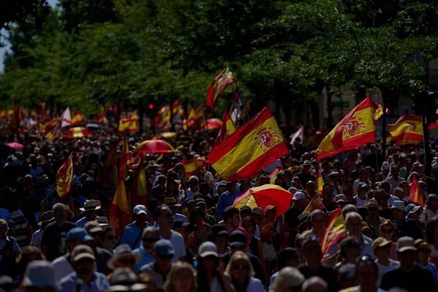 Manifestantes con banderas españolas participan en una protesta contra el gobierno del presidente Pedro Sánchez, en Madrid, España, el sábado 23 de mayo de 2026.