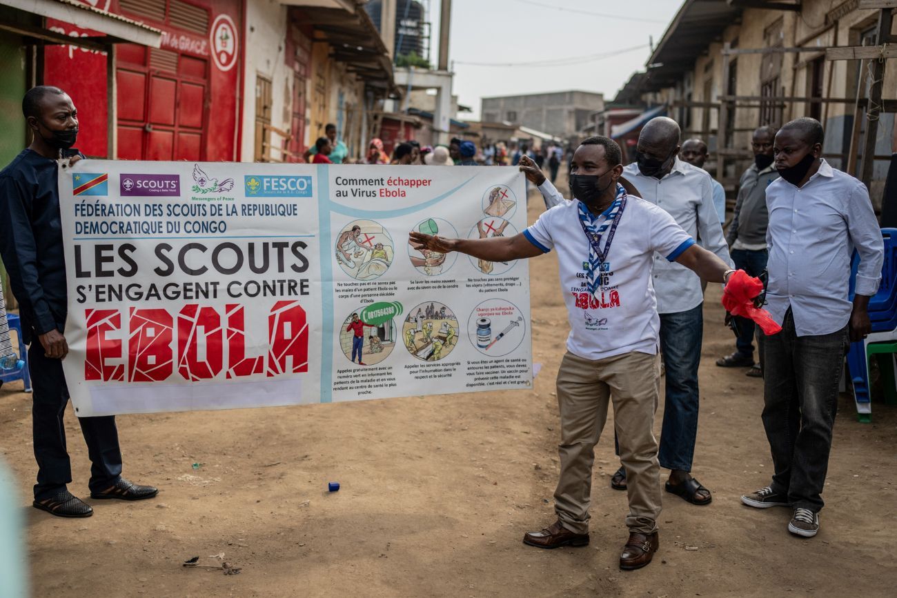 Miembros del movimiento de Scouts del Congo portan una pancarta de concientización sobre el Ébola por una calle durante una campaña de sensibilización pública en medio del brote de Ébola en Bunia, Congo, el sábado 23 de mayo de 2026. (Foto AP / Moses Sawasawa)
