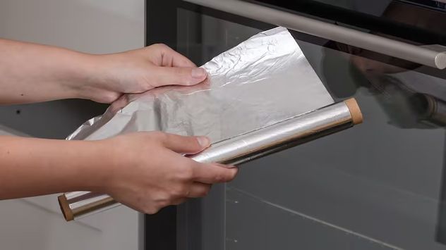 Cómo limpiar las bandejas del horno con papel aluminio y bicarbonato: el truco viral que elimina la grasa.