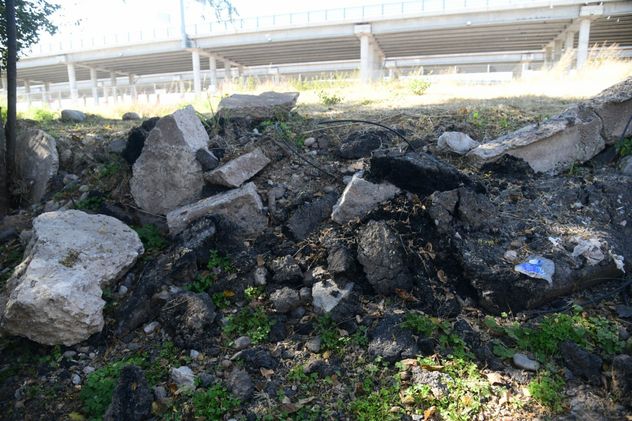 Restos de asfalto en las costas del río. (Ramiro Perera / La Voz)