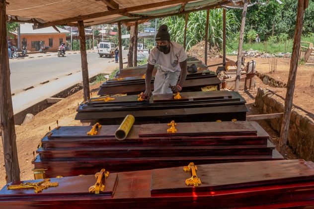 Djakisa Christian, de 18 años, administrador de una funeraria, desempolva ataúdes en venta en su tienda en Bunia, Congo, el 22 de mayo de 2026. (Moses Sawasawa)