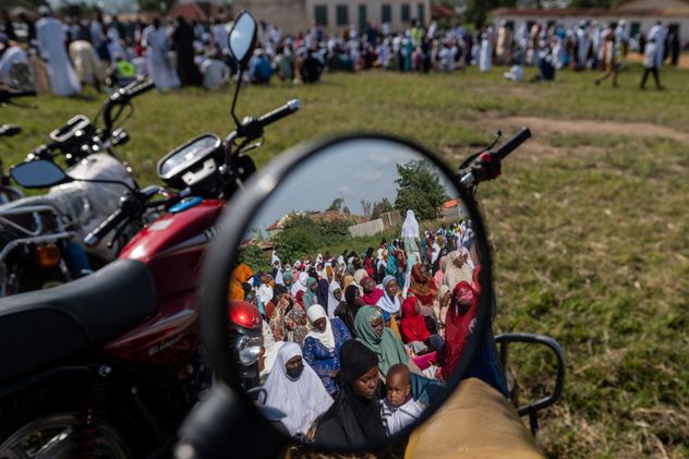 Los musulmanes se reflejan en el espejo de una motocicleta mientras se reúnen para rezar en la Escuela Sayo Muhamed durante la celebración del Eid al-Adha en medio de un brote de ébola en Bunia, Congo, el 27 de mayo de 2026. (Moses Sawasawa)