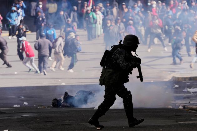 Un oficial de policía corre después de lanzar gas lacrimógeno a los manifestantes durante una demostración antigubernamental en La Paz, Bolivia, el 25 de mayo de 2026. (Juan Karita)
