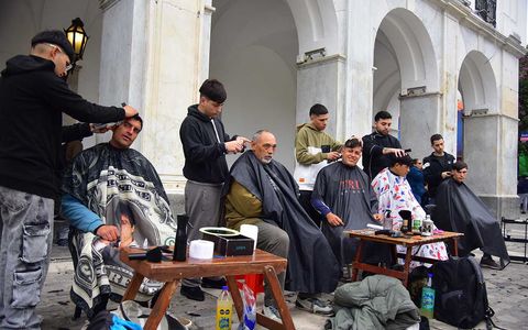 Peluqueros en el Cabildo de Córdoba. Jóvenes barberos ofrecen cortes a personas en situación de calle, en la Plaza San Martín. 