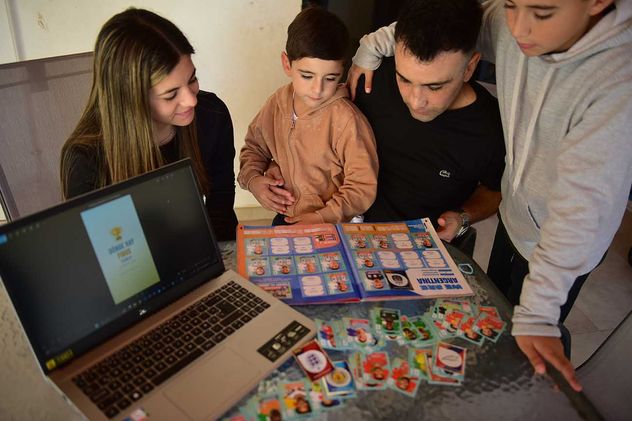 Ramiro con sus hijos y su esposa con el álbum y la app. (José Hernández / La Voz)