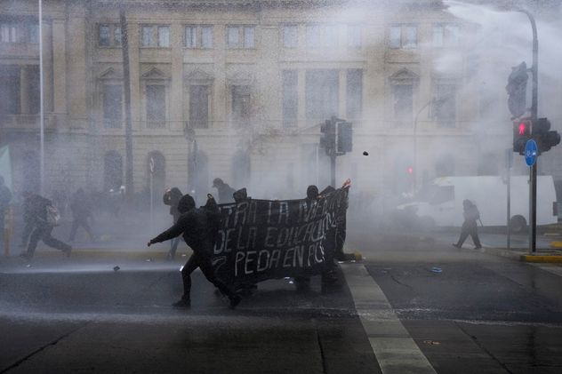 Estudiantes se enfrentan a la policía durante una protesta contra la propuesta del gobierno de reducir el presupuesto de educación, en Santiago de Chile, el miércoles 3 de junio de 2026. 