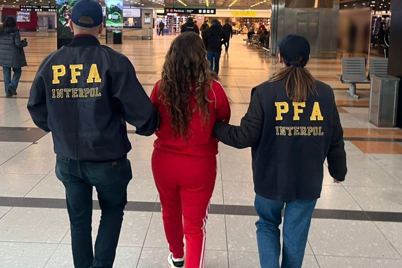 La mujer, al ser escoltada en el aeropuerto de Ezeiza, antes de su extradición. (PFA)