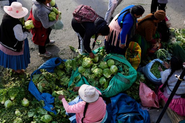 Productores de hortalizas venden sus productos a los compradores de la ciudad en un mercado improvisado en Avircato, Bolivia, instalado por vendedores que no pueden transportar sus verduras a la ciudad debido a los bloqueos de las protestas, el jueves 4 de junio de 2026. (Foto AP/Juan Karita)