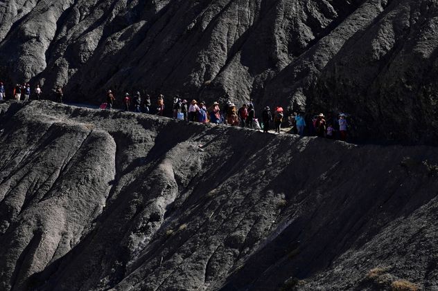 Varias personas caminan hacia un mercado improvisado en Avircato, Bolivia, organizado por productores que no pueden transportar sus verduras a la ciudad debido a los bloqueos provocados por las protestas, el jueves 4 de junio de 2026. (Foto AP/Juan Karita)