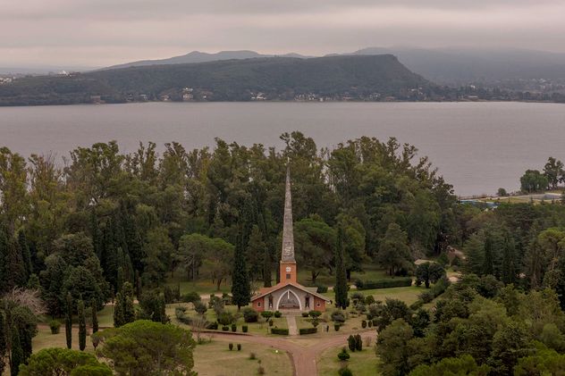 Unidad Turística Embalse. La incóica capilla en medio del arboaldo predio de los hoteles, con el lago de fondo. 