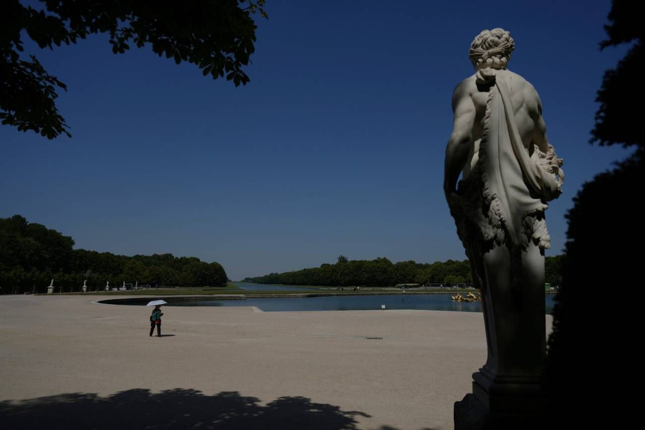 Imagen ilustrativa. Una mujer se protege del en el jardín del Palacio de Versalles, en las afueras de París, en Francia, en medio de la ola de calor.