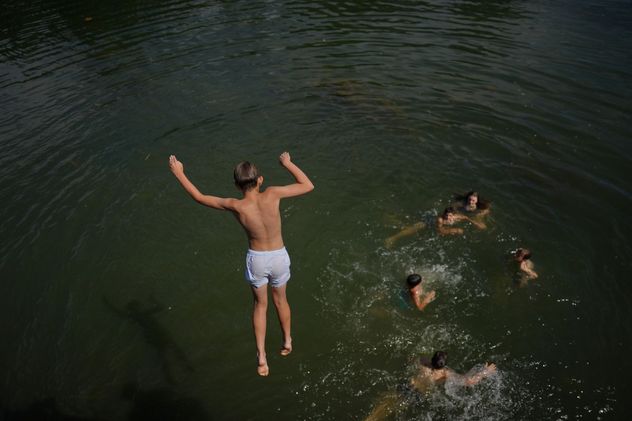Un niño pequeño se zambulle en el río Sena, en Samois-sur-Seine, al sur de París.