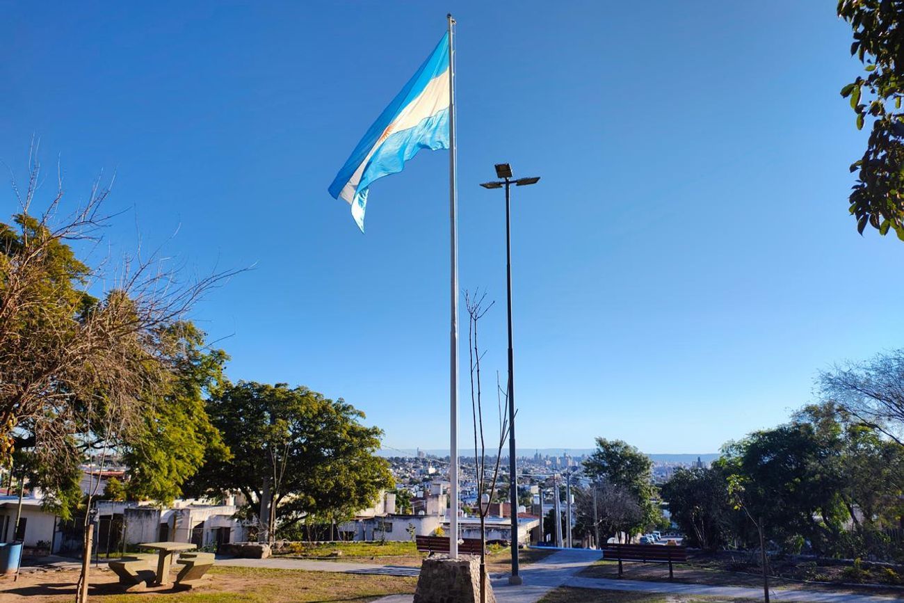 La bandera argentina flamea en lo alto de la ciudad de Córdoba, en el mástil de la plaza de la rotonda de barrio Parque San Vicente. 
