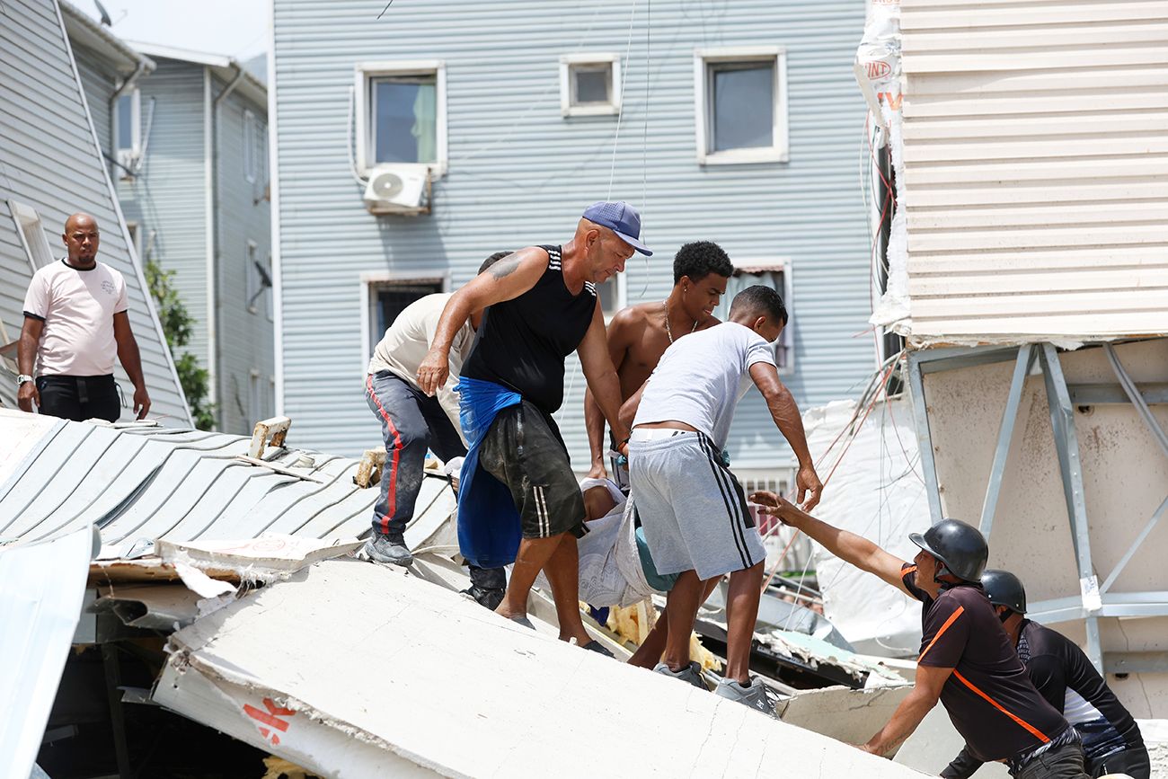Residentes y rescatistas buscan entre los escombros de un edificio que se derrumbó en los terremotos que sacudieron el día anterior en Caracas, Venezuela, jueves 25 de junio de 2026. 